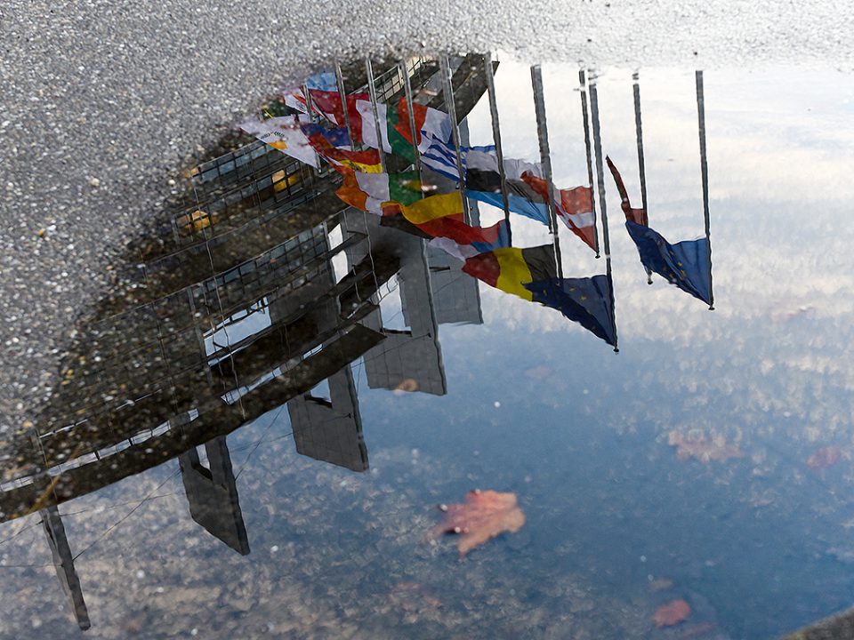 Fahnen in Strassburg gespiegelt in einer Wasserpfütze